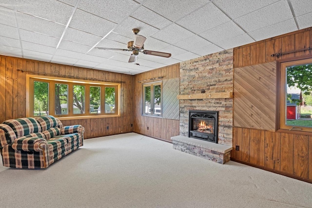 15 Wilson Ave, Fort Atkinson, WI 53538 - living room featuring wood walls, carpet flooring, ceiling fan, a fireplace, and baseboards