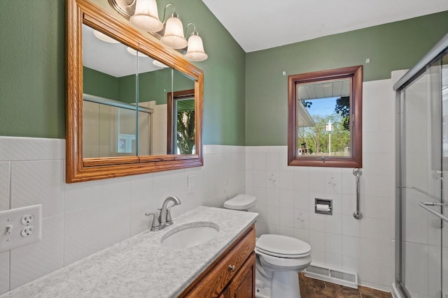 15 Wilson Ave, Fort Atkinson, WI 53538 - full bathroom featuring vanity, a stall shower, toilet, tile walls, and wainscoting