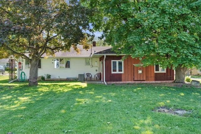 15 Wilson Ave, Fort Atkinson, WI 53538 - rear view of house with cooling unit, a lawn, and a chimney