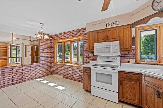 15 Wilson Ave, Fort Atkinson, WI 53538 - kitchen featuring white appliances, brick wall, brown cabinets, light countertops, and light tile patterned flooring