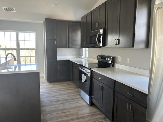 W141N9978 Seven Pines Way Unit 204, Germantown, WI 53022 - kitchen featuring appliances with stainless steel finishes, light wood-style flooring, light countertops, and a sink