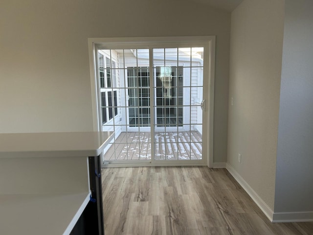 W141N9978 Seven Pines Way Unit 204, Germantown, WI 53022 - unfurnished dining area with wood finished floors, baseboards, and vaulted ceiling