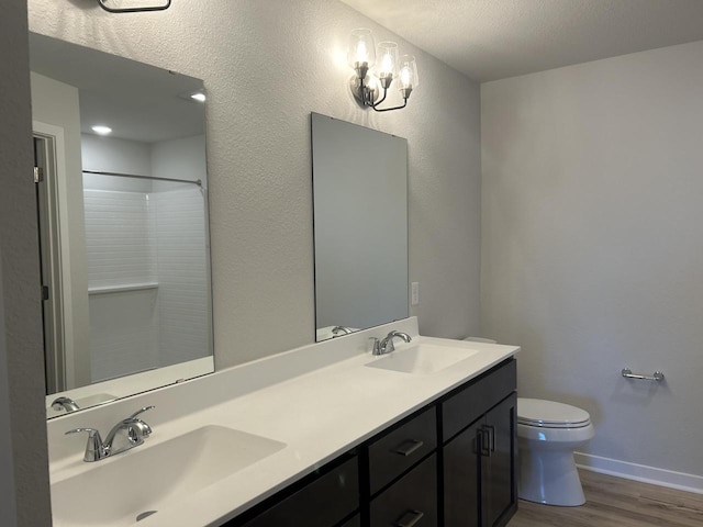 W141N9978 Seven Pines Way Unit 204, Germantown, WI 53022 - bathroom with wood finished floors, toilet, double vanity, baseboards, and a shower