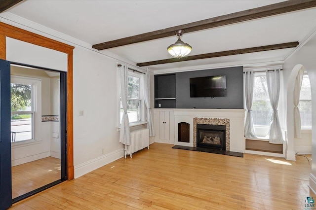 2127 Tower Ave, Superior, WI 54880 - unfurnished living room featuring radiator heating unit, healthy amount of natural light, beam ceiling, light wood-style floors, and a fireplace
