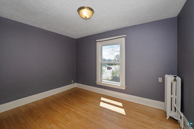 2127 Tower Ave, Superior, WI 54880 - unfurnished room featuring radiator, light wood finished floors, and baseboards