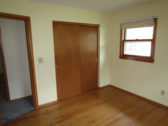 2374 S Park Ave, Beloit, WI 53511 - unfurnished bedroom with light wood finished floors, a closet, and baseboards