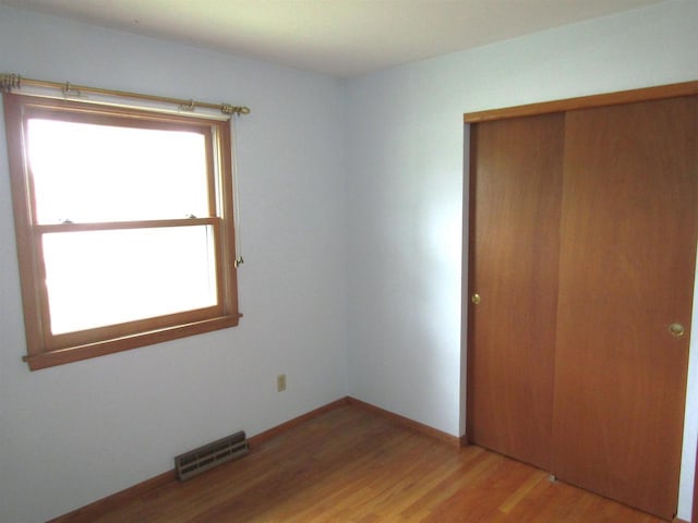2374 S Park Ave, Beloit, WI 53511 - unfurnished bedroom with a closet, light wood-style floors, and baseboards