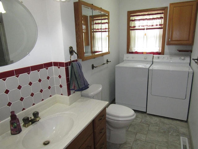 2374 S Park Ave, Beloit, WI 53511 - bathroom with separate washer and dryer, toilet, vanity, and stone finish flooring