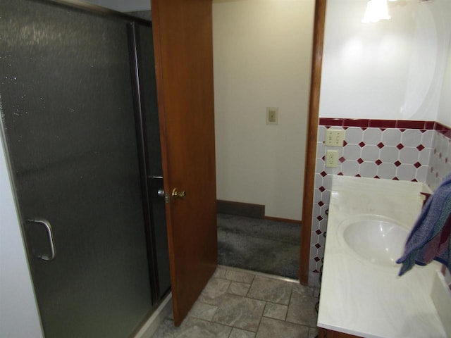 2374 S Park Ave, Beloit, WI 53511 - full bathroom featuring a stall shower, vanity, baseboards, and stone finish flooring