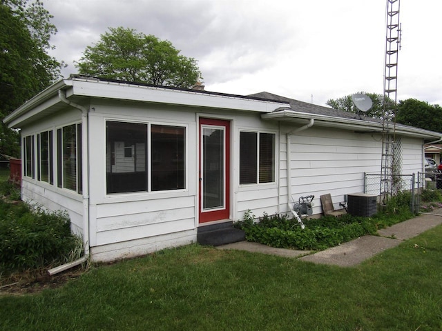 2374 S Park Ave, Beloit, WI 53511 - back of property with central AC, a chimney, and a sunroom