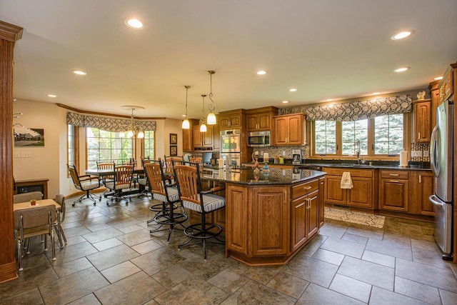 800 Ridge Ave, Platteville, WI 53818 - kitchen with stainless steel appliances, plenty of natural light, a kitchen breakfast bar, recessed lighting, and brown cabinets