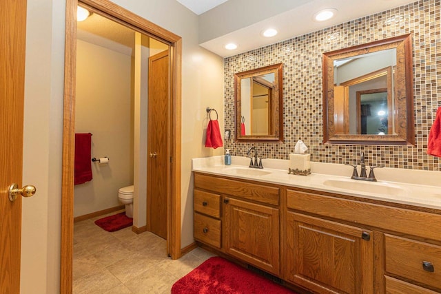 800 Ridge Ave, Platteville, WI 53818 - bathroom featuring double vanity, toilet, backsplash, tile patterned floors, and baseboards