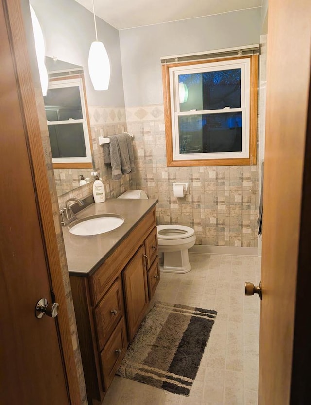 3434 Kentucky St, Racine, WI 53405 - bathroom with vanity, toilet, a wainscoted wall, and tile walls