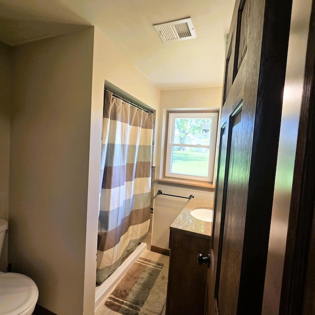 3434 Kentucky St, Racine, WI 53405 - full bathroom featuring toilet, vanity, curtained shower, and wood finished floors