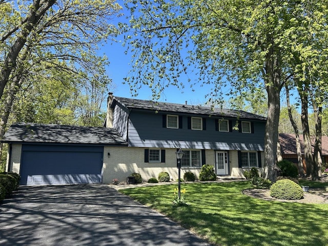 4034 Chicory Rd, Mount Pleasant, WI 53403 - colonial house with asphalt driveway, a chimney, brick siding, and a garage