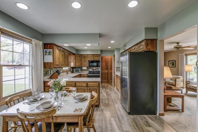 4034 Chicory Rd, Mount Pleasant, WI 53403 - kitchen featuring appliances with stainless steel finishes, brown cabinetry, light wood-style flooring, light countertops, and backsplash