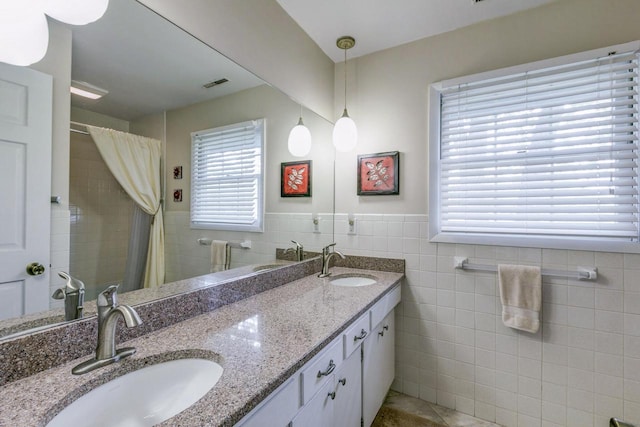 4034 Chicory Rd, Mount Pleasant, WI 53403 - full bath featuring tile walls, double vanity, a wainscoted wall, curtained shower, and tile patterned flooring