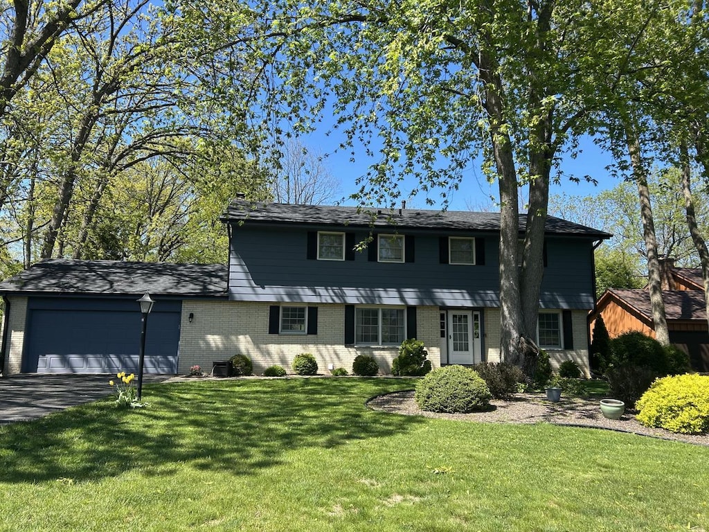 4034 Chicory Rd, Mount Pleasant, WI 53403 - colonial home with an attached garage, brick siding, asphalt driveway, and a front lawn
