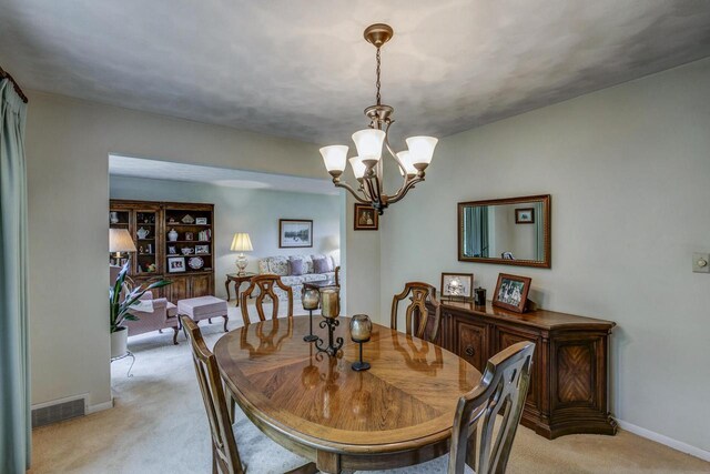 4034 Chicory Rd, Mount Pleasant, WI 53403 - dining room with light colored carpet, a chandelier, and baseboards