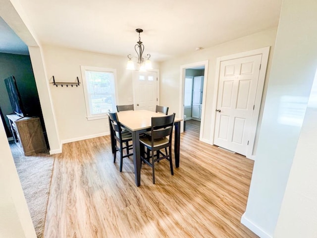 509 E Jefferson St, Stoughton, WI 53589 - dining room with light wood finished floors, baseboards, and a chandelier