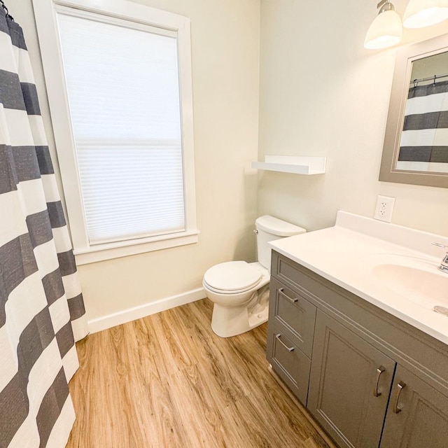 509 E Jefferson St, Stoughton, WI 53589 - bathroom featuring vanity, wood finished floors, toilet, and baseboards