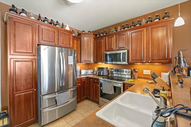 1300 School St Unit 209, Sun Prairie, WI 53590 - kitchen featuring stainless steel appliances, a sink, brown cabinets, and a textured ceiling