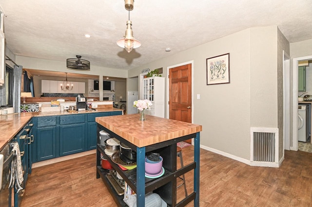 1081 E Elm Rd, Oak Creek, WI 53154 - kitchen featuring blue cabinetry, wood counters, a chandelier, wood finished floors, and baseboards