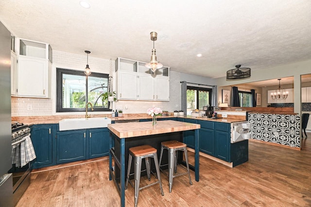 1081 E Elm Rd, Oak Creek, WI 53154 - kitchen with a sink, blue cabinets, a peninsula, stainless steel gas stove, and white cabinetry