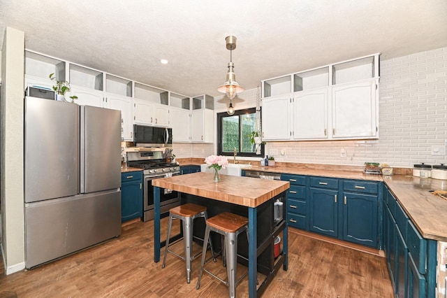 1081 E Elm Rd, Oak Creek, WI 53154 - kitchen with stainless steel appliances, butcher block countertops, blue cabinetry, white cabinetry, and a textured ceiling