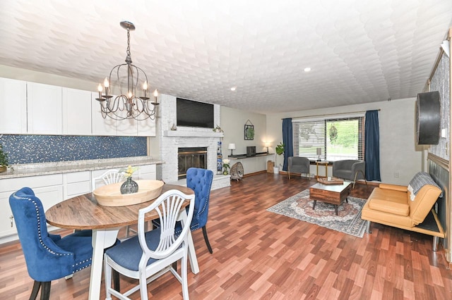 1081 E Elm Rd, Oak Creek, WI 53154 - dining area with a large fireplace, a chandelier, and wood finished floors