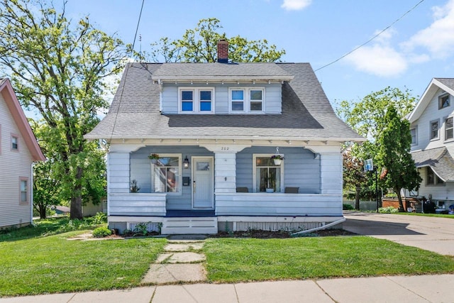 202 Lake St, Mount Horeb, WI 53572 - bungalow-style house with covered porch, a front lawn, a chimney, and roof with shingles