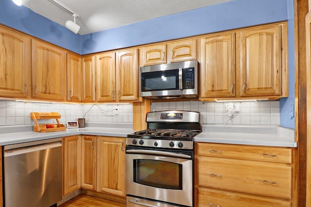 202 Lake St, Mount Horeb, WI 53572 - kitchen with appliances with stainless steel finishes, light countertops, light wood-style floors, and backsplash