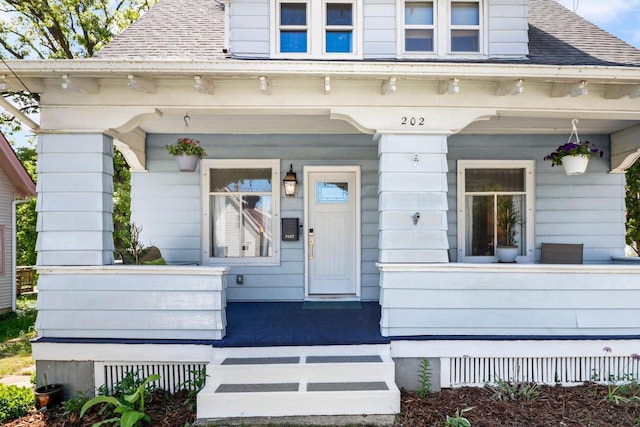 202 Lake St, Mount Horeb, WI 53572 - view of exterior entry featuring a porch and roof with shingles