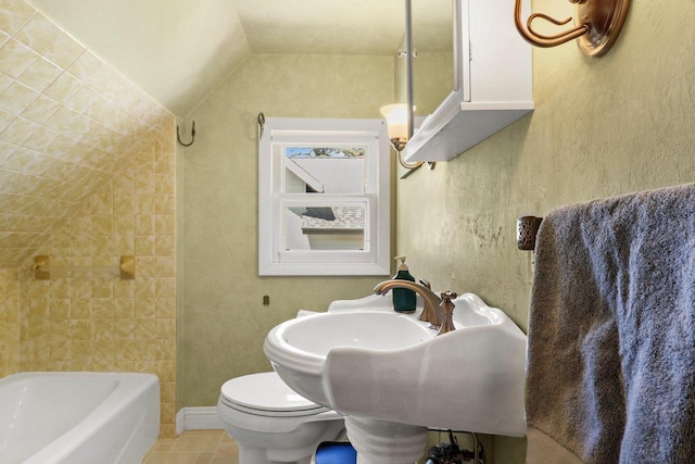 202 Lake St, Mount Horeb, WI 53572 - full bath with tile patterned floors, vaulted ceiling, toilet, and baseboards