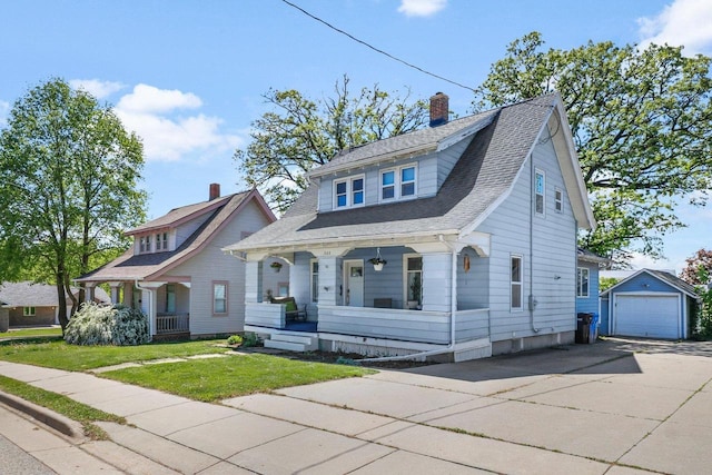 202 Lake St, Mount Horeb, WI 53572 - view of front facade featuring covered porch, driveway, a detached garage, an outdoor structure, and a chimney