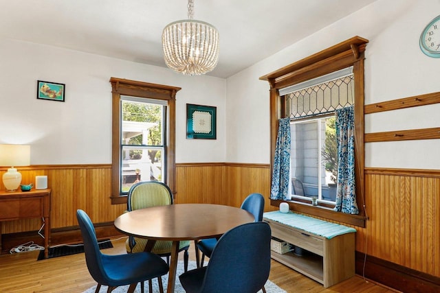 202 Lake St, Mount Horeb, WI 53572 - dining space with a wainscoted wall, a chandelier, wood walls, and wood finished floors