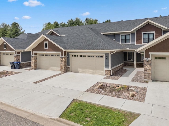 1512 Lake St, Baraboo, WI 53913 - craftsman-style home with stone siding, a shingled roof, a garage, and concrete driveway