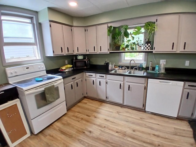 206 W Winnebago St, Appleton, WI 54911 - kitchen with white appliances, a sink, dark countertops, and light wood finished floors