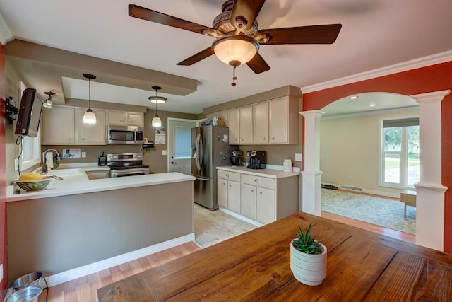 1621 W Crystal Dr, Edgerton, WI 53534 - kitchen with stainless steel appliances, decorative columns, ceiling fan, arched walkways, and light countertops