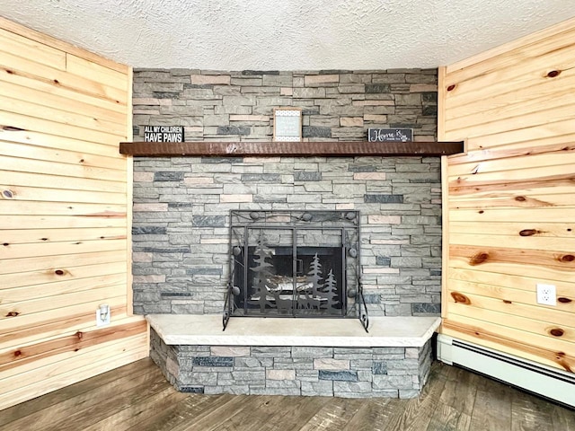 N11893 Pratt Rd, Elcho, WI 54428 - detailed view of baseboard heating, a textured ceiling, wood finished floors, and a fireplace