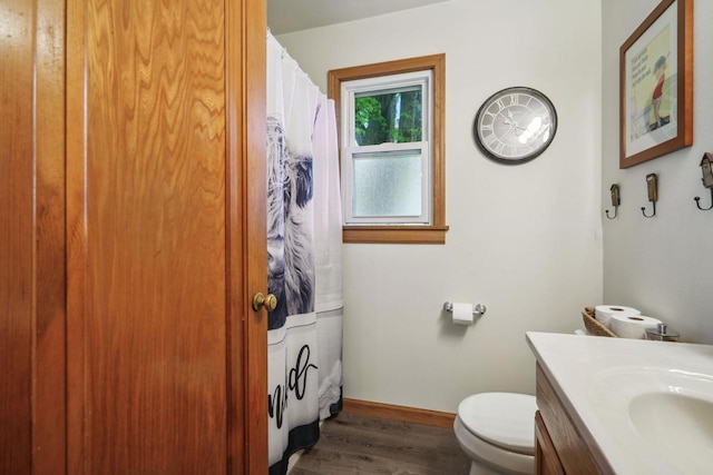 60 Madison Ave, Port Edwards, WI 54469 - bathroom featuring vanity, wood finished floors, toilet, baseboards, and curtained shower