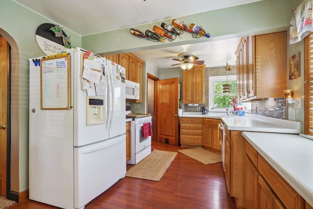 60 Madison Ave, Port Edwards, WI 54469 - kitchen featuring white appliances, arched walkways, dark wood finished floors, light countertops, and a sink
