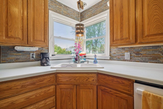 60 Madison Ave, Port Edwards, WI 54469 - kitchen featuring dishwasher, a sink, backsplash, brown cabinets, and light countertops