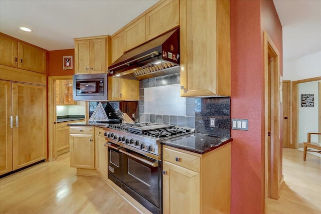6625 Charles St, Racine, WI 53402 - kitchen with double oven range, stainless steel microwave, under cabinet range hood, decorative backsplash, and light wood-style floors