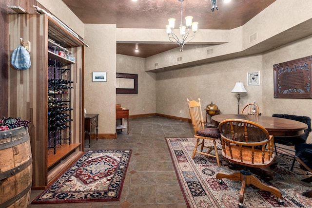 6625 Charles St, Racine, WI 53402 - dining area with baseboards, a textured wall, dark tile patterned floors, and a chandelier