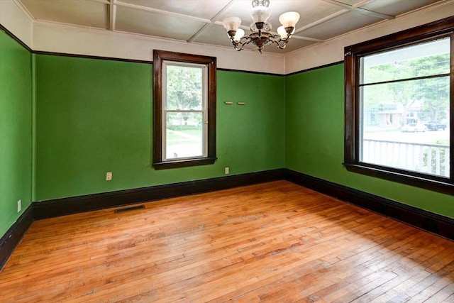 1235 Chandler St, Madison, WI 53715 - empty room featuring light wood-style flooring, a chandelier, baseboards, and ornamental molding