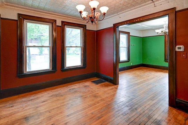 1235 Chandler St, Madison, WI 53715 - unfurnished room with a chandelier, crown molding, wood-type flooring, an ornate ceiling, and baseboards
