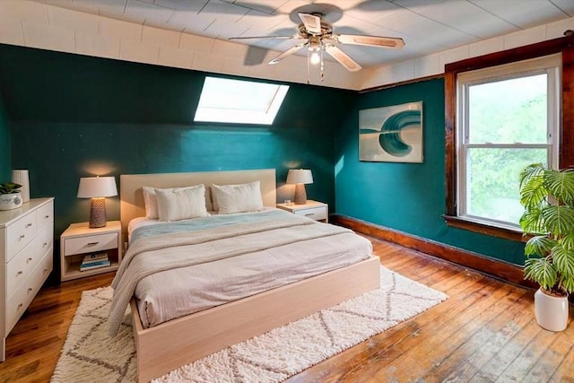 1235 Chandler St, Madison, WI 53715 - bedroom featuring a skylight, hardwood / wood-style flooring, an accent wall, and baseboards