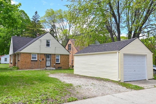 5002 N 24th Pl, Milwaukee, WI 53209 - view of front of house featuring an outdoor structure, a detached garage, a front lawn, brick siding, and roof with shingles