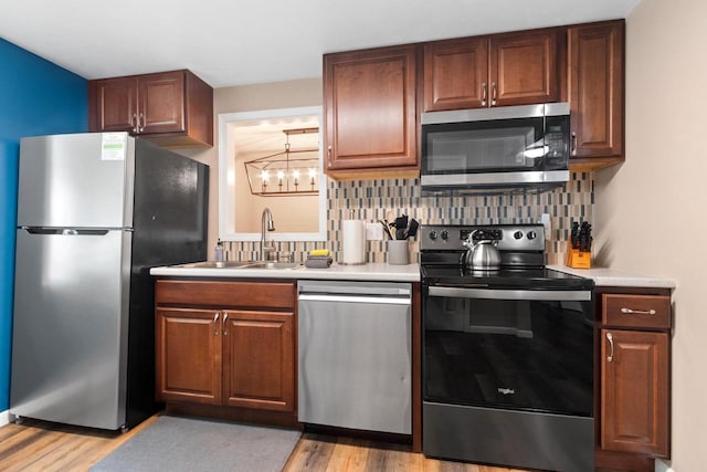 1254 Thorndale St, Green Bay, WI 54304 - kitchen featuring appliances with stainless steel finishes, a sink, light wood finished floors, and tasteful backsplash